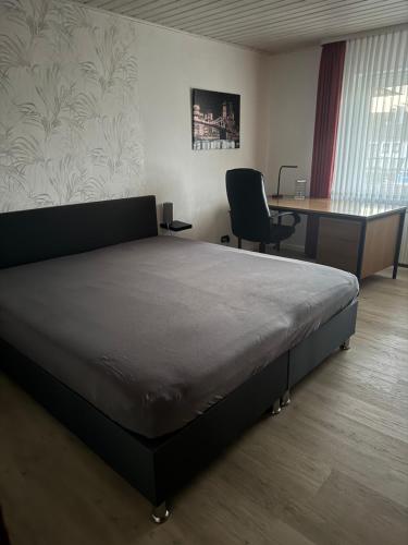 a bedroom with a bed and a desk and a chair at Ferienwohnungjahrsfeld in Straßenhaus