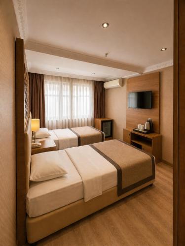 a hotel room with two beds and a television at Prens Hotel Istanbul by GKRY Hotels Group - Tram And Metro Stops Are Just a Few Min Walk Away in Istanbul