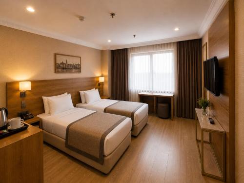 a hotel room with two beds and a television at Prens Hotel Istanbul by GKRY Hotels Group - Tram And Metro Stops Are Just a Few Min Walk Away in Istanbul