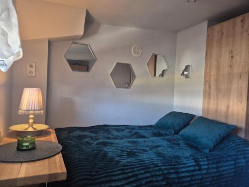 a bedroom with a blue bed and a table with a lamp at Radiowa mini in Warsaw
