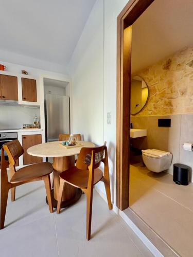 a kitchen with a table and chairs and a toilet at Kapetánissa Concept Studios in Stalís