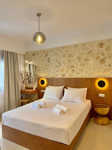a bedroom with a large bed with towels on it at Kapetánissa Concept Studios in Stalís