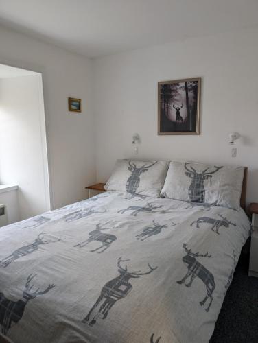 a bed with a blanket with deer on it at Scoor House - Cruachan in Bunessan