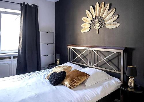 ein Schlafzimmer mit einem Bett und Kissen darauf in der Unterkunft Nouveau - L'Entre Nous - Europa Park in Huttenheim