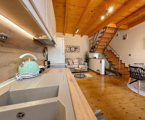 a kitchen and living room with a spiral staircase at Vilia Port House- Corfu Centre in Mantoúkion