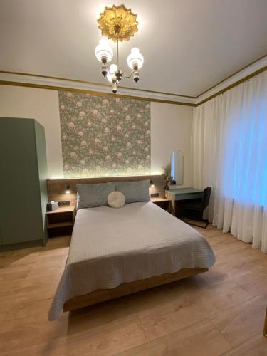 a bedroom with a bed and a chandelier at Zviedru Nams in Liepāja