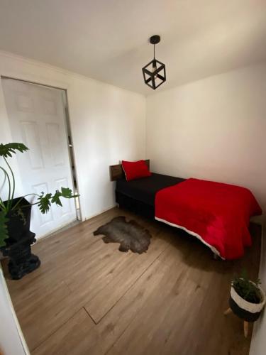 a bedroom with a bed with a red comforter at Tinajas martina in Las Cruces
