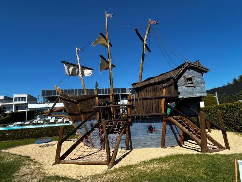 a playground with a house and flags on it at LakeView 59 Lemon Resort Spa in Gródek Nad Dunajcem