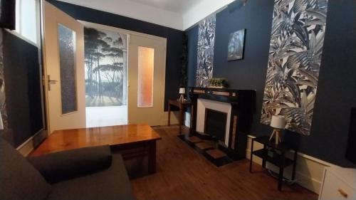 a living room with a fireplace and a table at 50 nuances de couleurs in Arinthod