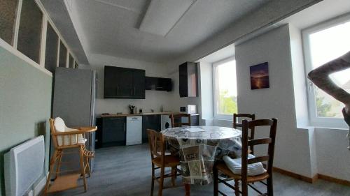 a kitchen and dining room with a table and chairs at 50 nuances de couleurs in Arinthod