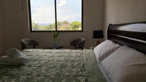 a bedroom with two beds and a large window at Panáveda Ayurvedic Wellness Centre in El Creo