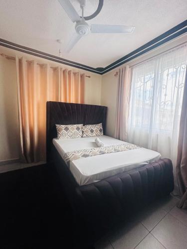 a bed sitting in a room with a window at Honned homes in Mombasa