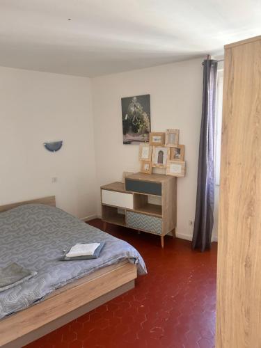 a bedroom with a bed and a dresser in it at Charmant T3 au centre de gréoux les bains in Gréoux-les-Bains
