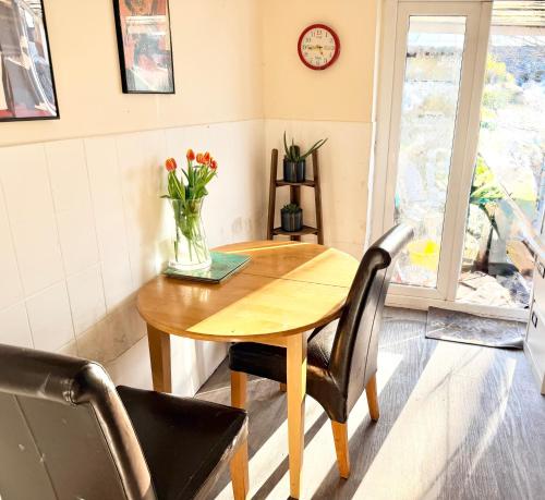 a wooden table with a vase of flowers on it at Smart Double Room in Reading
