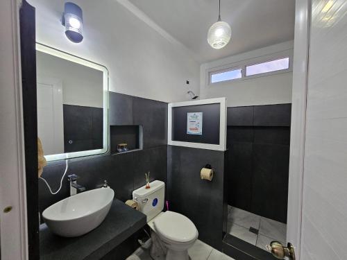 a bathroom with a white sink and a toilet at Modern AC Excellent location in Los Jocotes