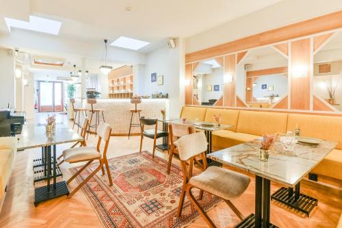 a restaurant with tables and chairs and a couch at Hotel Habituel in Paris