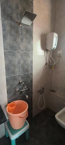 a bathroom with a bucket and a shower and a sink at Shivoham holiday villa in Dapoli