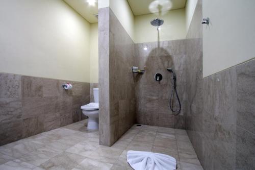 a bathroom with a shower and a toilet at Byasa Ubud in Ubud