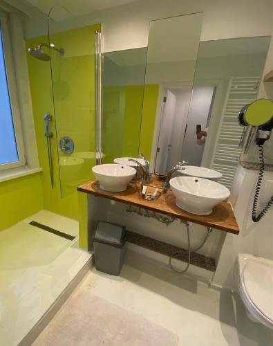 a bathroom with two sinks and a shower at Hotel De Backer in Knokke-Heist