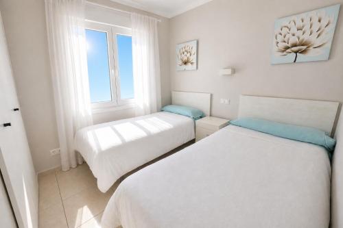 two beds in a small room with a window at Apartamento en Olivanova in Casas Devesa