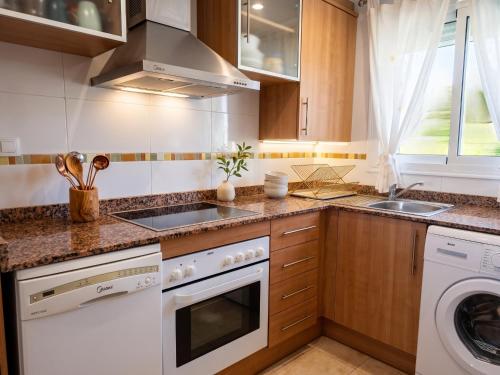 a kitchen with a sink and a dishwasher at Jardines del mar III-2ª linea de playa Piscina y Parking Ideal familias Marina d'Or in El Borseral
