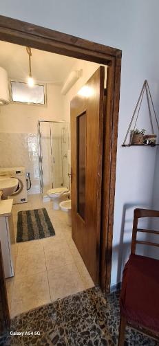 a bathroom with a toilet and a sink and a door at B&B Sa Rocca Manna in Laerru