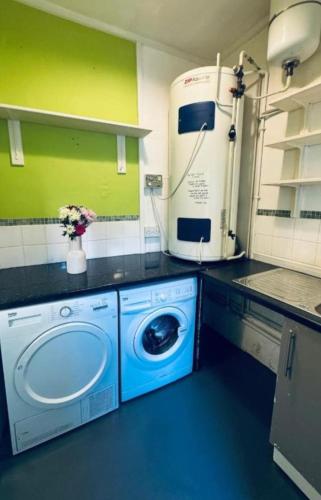 a washer and dryer in a kitchen with green walls at Harrington House - Perfect for contractors Sleeps 15 in Workington