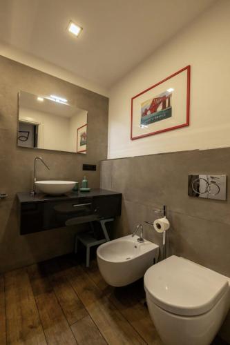 a bathroom with a white toilet and a sink at Alloggio Fronte Egizio in Turin