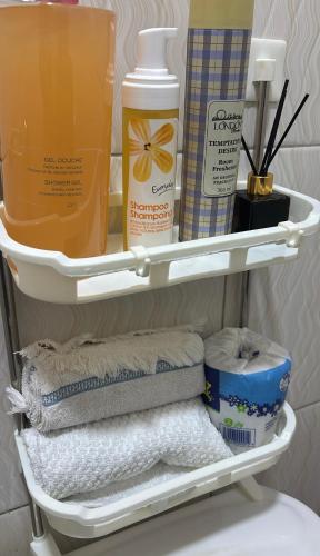 a shelf with towels and other products in a bathroom at Amber Home Kigali in Kigali