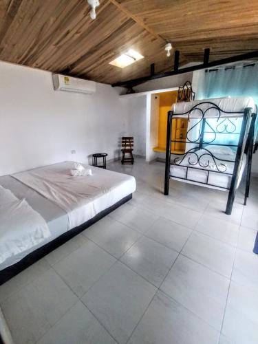 a large room with a bed and a chair at Hotel Coralite Suites Santa Marta in Santa Marta