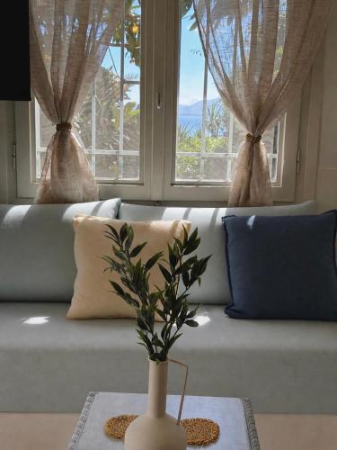 ein Wohnzimmer mit einer Couch und zwei Fenstern in der Unterkunft Alkionis Studio in Vari