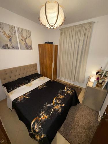 a bedroom with a bed with a black blanket with flowers on it at Dar Ifrane in Ifrane