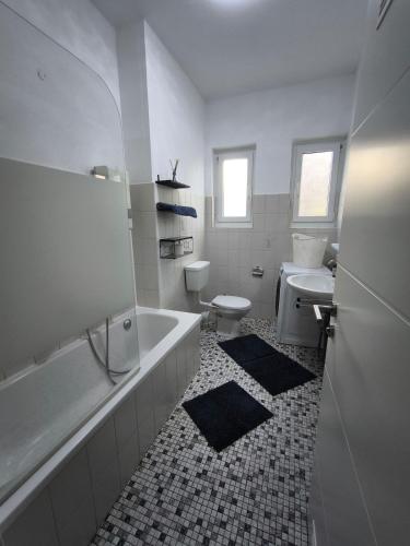 a bathroom with a tub and a toilet and a sink at FEWO Leonie 3 Schlafzimmer Apartment in Hückeswagen