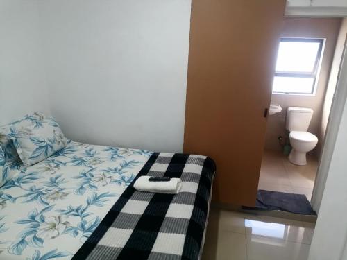 a bedroom with a bed and a bathroom with a toilet at 48 the trout lodge in Goodwood