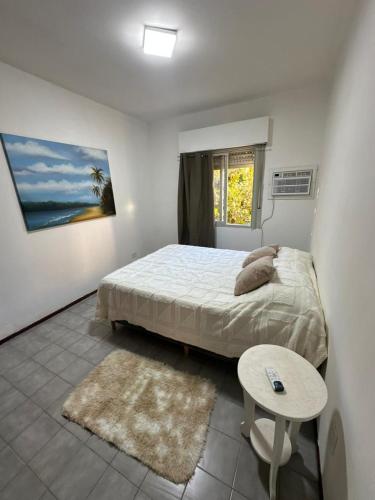 a bedroom with a bed and a table and a window at La Pausa Misiones in Posadas