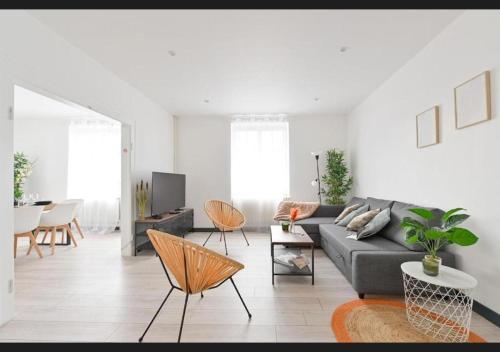 a living room with a gray couch and chairs at Le sympathique in Ittenheim