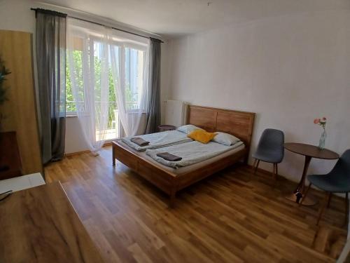 a bedroom with a bed and a table and a window at Pokoje z balkonami & Parking, 300m do Molo in Sopot