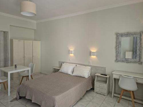 a bedroom with a bed and a table and a mirror at Aktio Studios in Gavrio