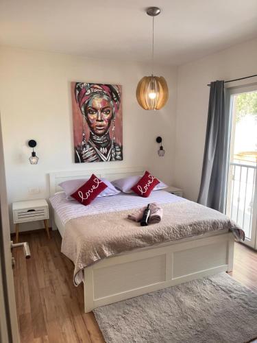 a bedroom with a bed with a painting on the wall at Luxury apartment Duće with private pool in Omiš