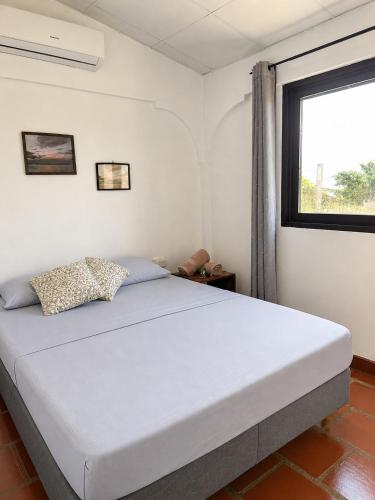 a bedroom with a large bed with a window at The Corner Hostel in Playa Blanca