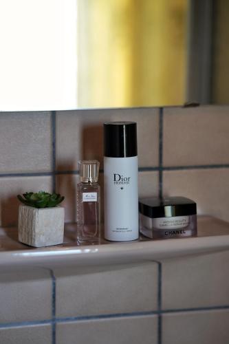 a bathroom shelf with a bottle of perfume and other cosmetics at Waldhotel Einstein in Kirchhundem