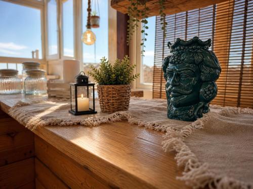 a table with a candle and a bust of a head at Suites Sangiovanni in Ragusa