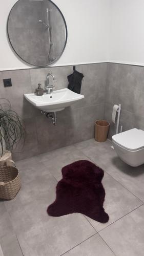 a bathroom with a sink and a purple rug on the floor at My Wellness Ferienwohnung in Bullay