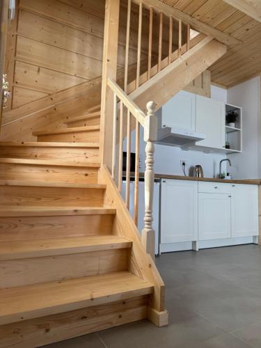a wooden staircase in a kitchen with white cabinets at Domek Pod Tatrami - Koniówka, blisko Term Chochołowskich in Koniówka