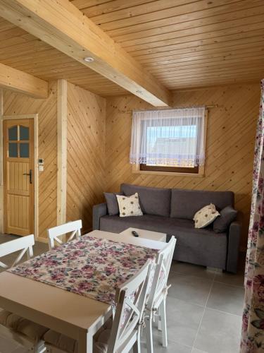 a living room with a table and a couch at Domek Pod Tatrami - Koniówka, blisko Term Chochołowskich in Koniówka