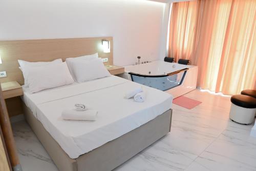 ein Schlafzimmer mit einem großen Bett und einer Badewanne in der Unterkunft Max Kriti Hotel in Shëngjin