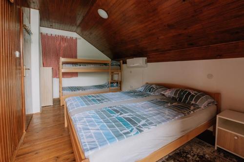 a bedroom with a bed with a wooden ceiling at Vintage house Jablanica Lake in Železnička Stanica Jablanica Grad