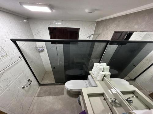 a bathroom with a toilet and a shower at Pousada Convés - Ilha Grande in Praia de Araçatiba