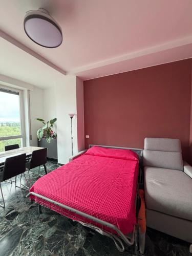 a bedroom with a red bed and a table at STANZA matrimoniale metro M5 - Bignami, Carroponte in Sesto San Giovanni