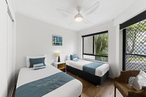 a bedroom with two beds and a window at Spinnaker Quays in Mooloolaba